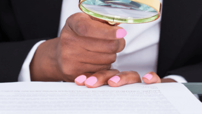 Man looking at legal forms through a magnifying glass