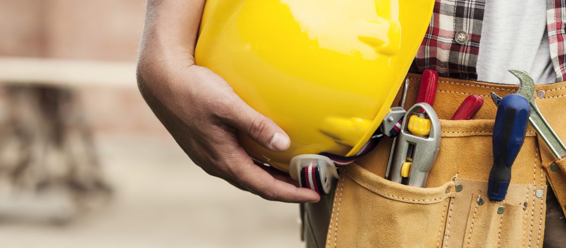 Close-up of hard hat holding by construction worker