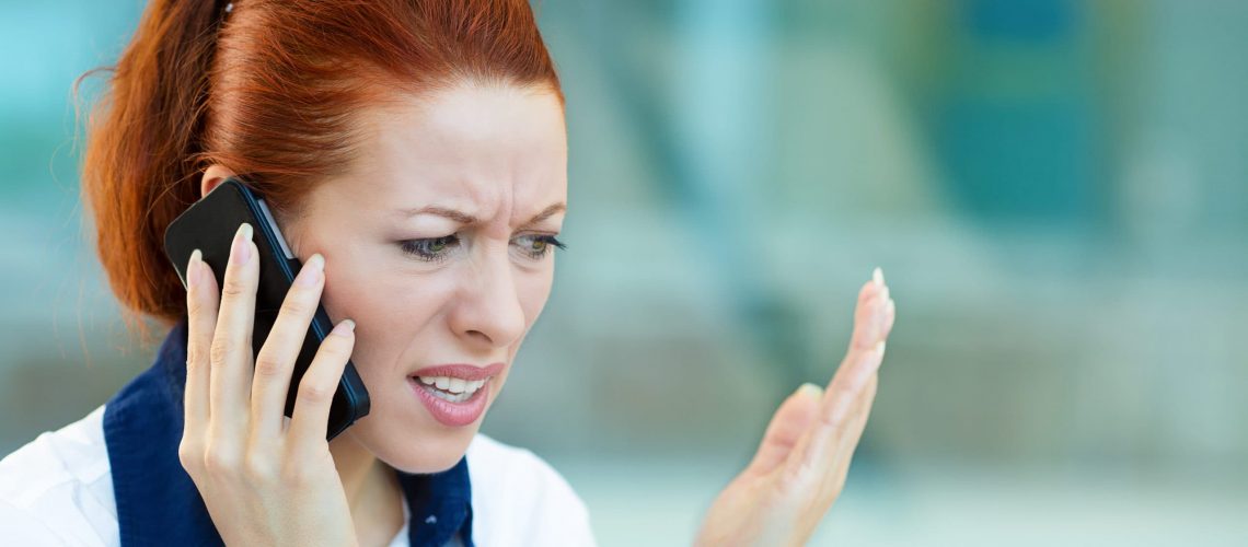 Closeup portrait upset sad, skeptical, unhappy, serious woman talking on phone, walking in hallway isolated office background. Negative human emotion facial expression feeling, life reaction. Bad news