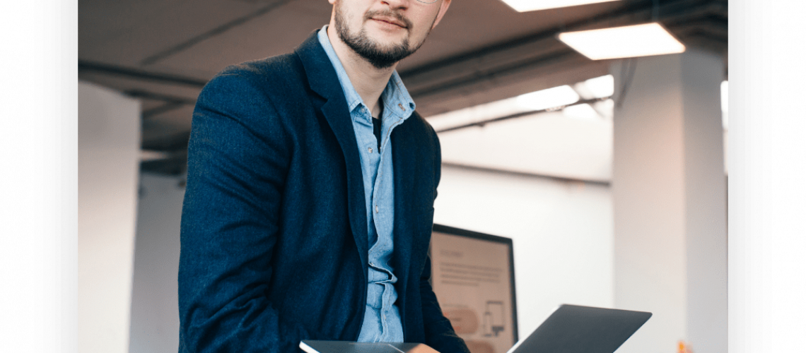 Professor of a university sitting on a desk